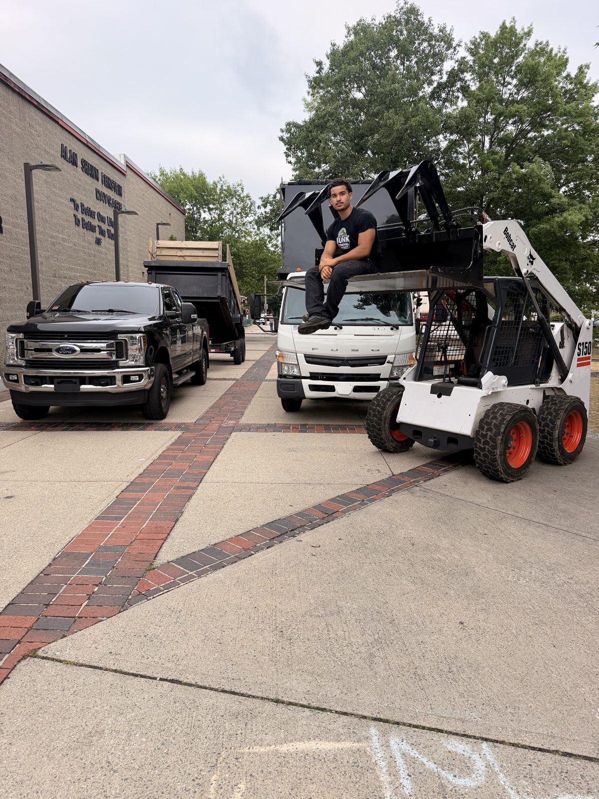 Crew member operating a skid steer loading the dump truck