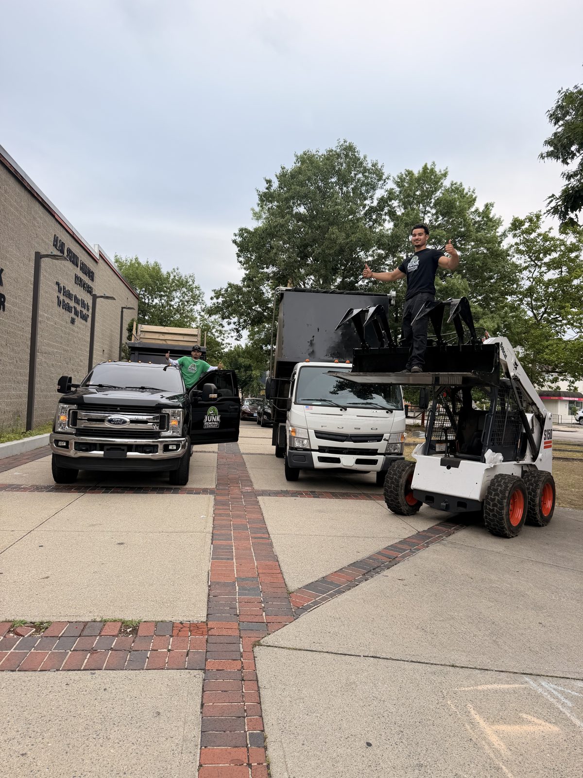 Skid steer loading debris into the company dump truck